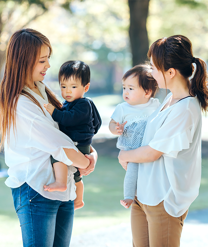 赤ちゃんを抱っこした女性二人が交流している写真