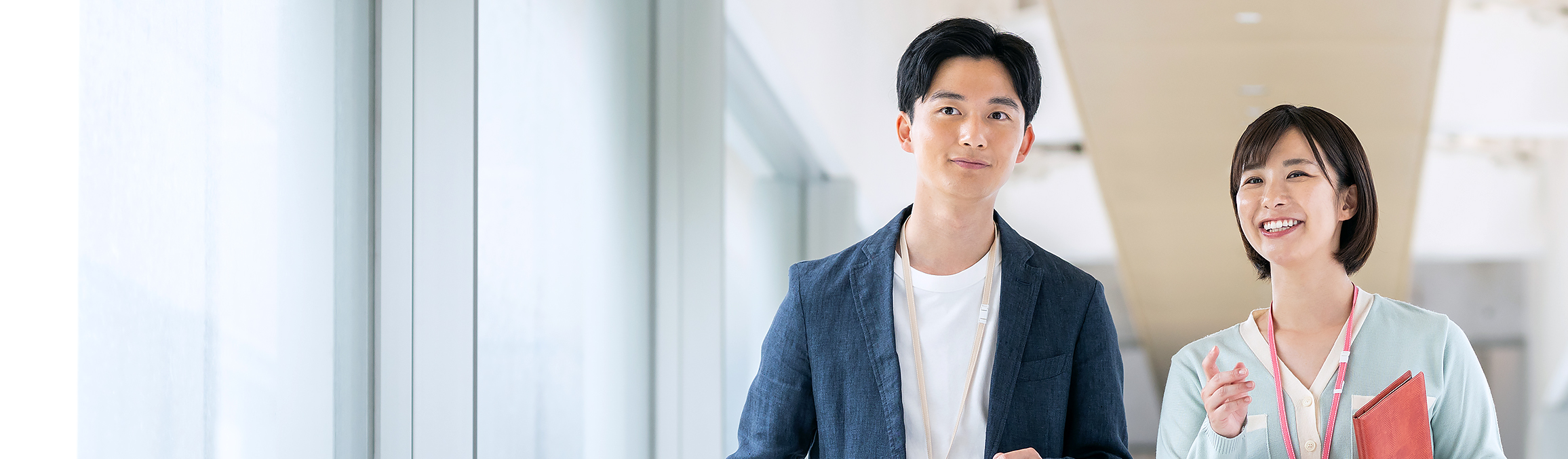 男性社員と女性社員が話しながら歩いている様子の写真