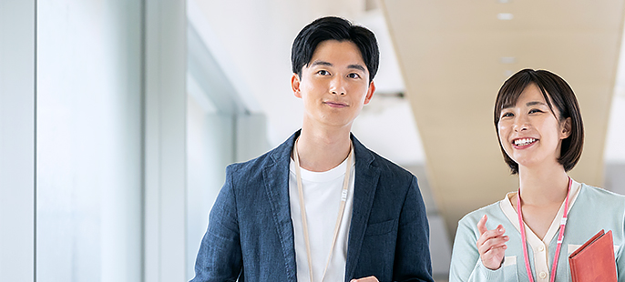男性社員と女性社員が話しながら歩いている様子の写真